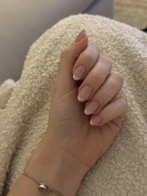 Mano con uñas francesitas con glitter