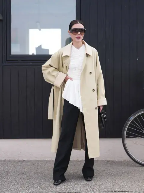 Mujer con trench y pantalones negros y lentes de sol Mujer con trench y pantalones negros y lentes de sol