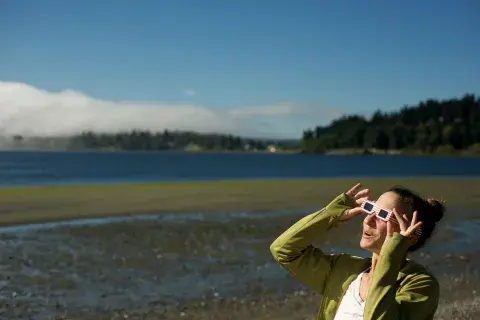 Mujer mirando el eclipse con lentes especiales Mujer mirando el eclipse con lentes especiales