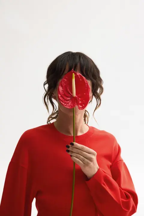 Natalia Oreiro tapándose la cara con una cala roja. Natalia Oreiro tapándose la cara con una cala roja.
