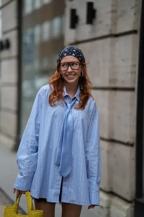 Una mujer con una camisa celeste y un pañuelo en la cabeza Una mujer con una camisa celeste y un pañuelo en la cabeza