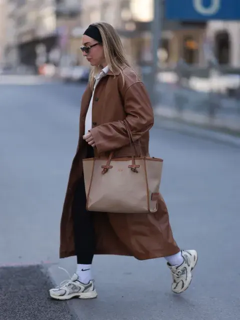 una mujer con tapado largo y zapatillas
