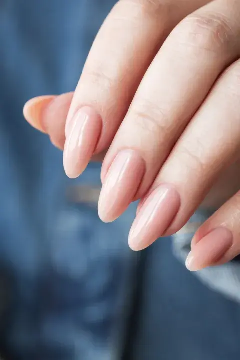 Una mujer con uñas en color nude