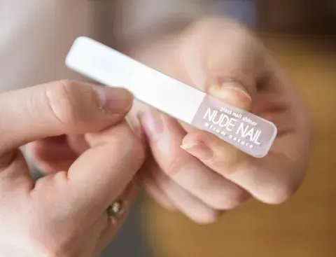 Una mujer limándose las uñas
