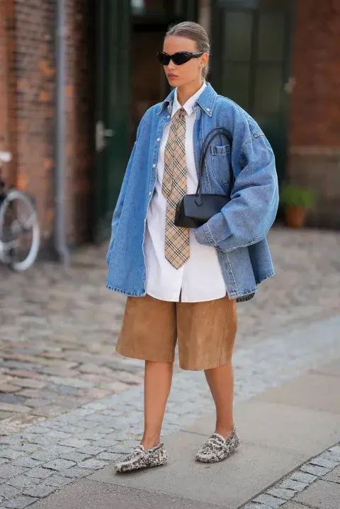 Una mujer llevando prendas oversize en el street style en la semana de la moda en Copenhague Una mujer llevando prendas oversize en el street style en la semana de la moda en Copenhague