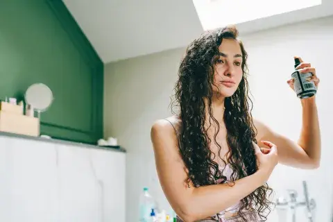 Una mujer con rulos peinandose Una mujer con rulos peinandose