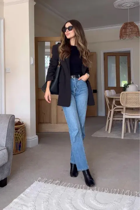 Una mujer con look en negro y jean recto Una mujer con look en negro y jean recto
