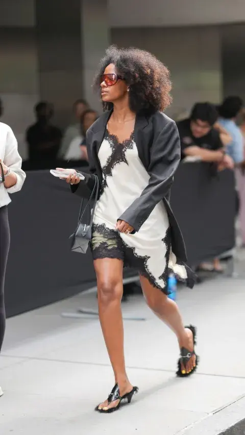 Una mujer caminando por New York con un vestido lencero durante la Semana de la Moda