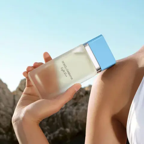 Una mujer con un perfume en la mano dolce y gabana 