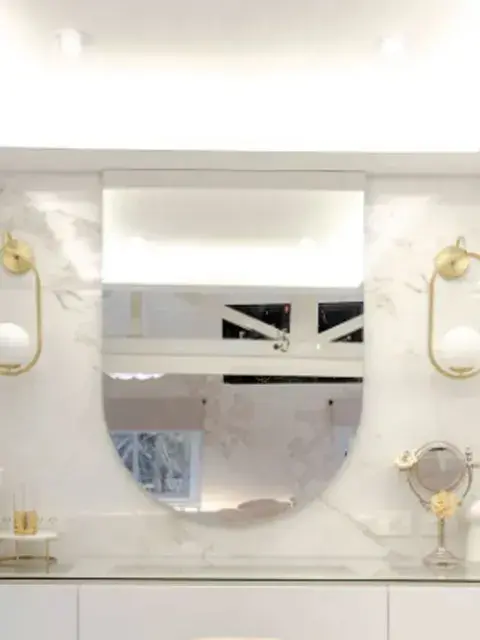 La combinación de blanco, beige, mármol, vidrio y dorado genera un resultado sofisticado sin necesidad de recurrir a demasiados elementos decorativos.