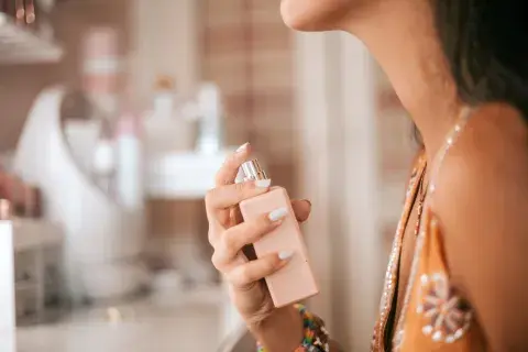 Mujer probando aroma de perfume en el baño Mujer probando aroma de perfume en el baño