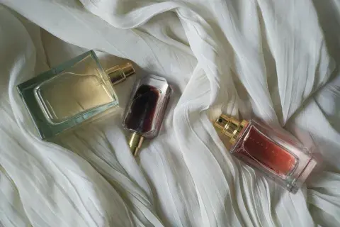Tres perfumes sobre una sábana blanca