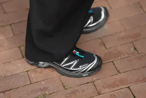 Una mujer en Amsterdam fashion week con un look de street style con unas zapatillas salomon en color negras