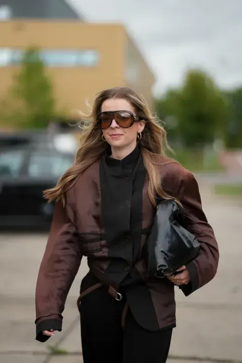 Una mujer en Amsterdam fashion week con un look de street style con un look sobrio y gafas XL