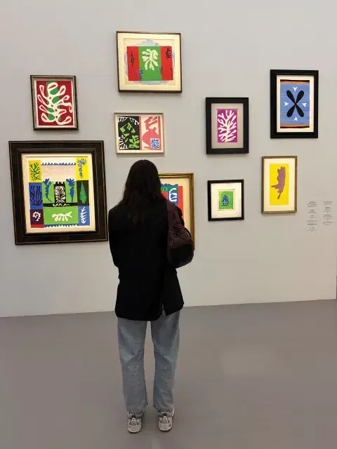 Una mujer de espaldas observando una muestra de arte Una mujer de espaldas observando una muestra de arte