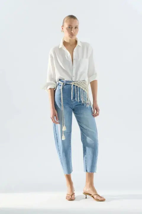 Una mujer usando un jean cropped celeste claro Una mujer usando un jean cropped celeste claro