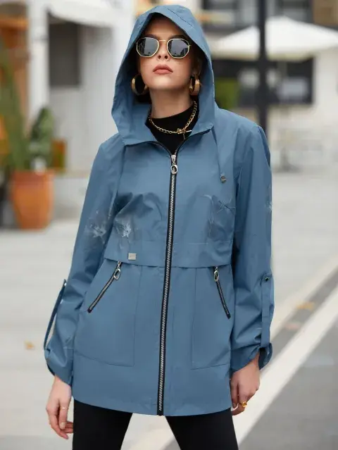 Una mujer con campera rompeviento en color azul petróleo Una mujer con campera rompeviento en color azul petróleo