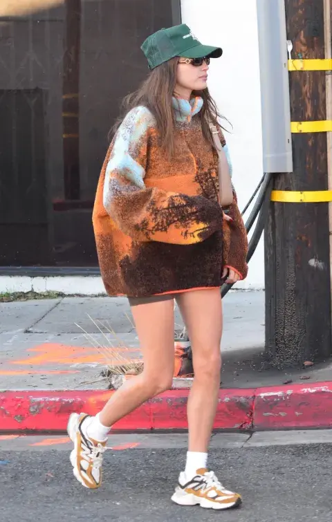 una joven caminando por la calle con gorra y sweater gorpcore una joven caminando por la calle con gorra y sweater gorpcore