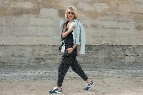una mujer caminando por la calle con look sporty glam una mujer caminando por la calle con look sporty glam
