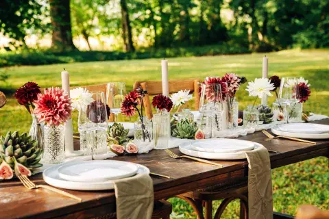 una mesa con flores y velas en el campo una mesa con flores y velas en el campo