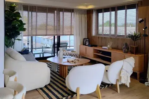 Cortinas americanas de madera; en la ventana más grande, tras unas de gasa 'Lime Cream' (ambas de Hunter Douglas por Delia Mucci). Poltronas de bouclé, alfombra, mesas de centro y consola (Estudio GOD). Cortinas americanas de madera; en la ventana más grande, tras unas de gasa 'Lime Cream' (ambas de Hunter Douglas por Delia Mucci). Poltronas de bouclé, alfombra, mesas de centro y consola (Estudio GOD).