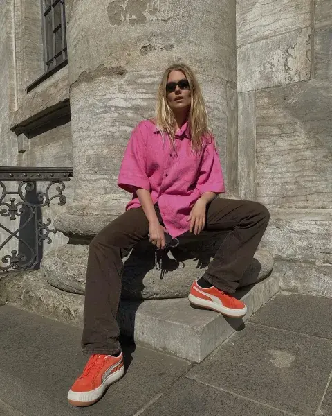 Una mujer usando Zapatillas de colores Puma Sude en color naranja Una mujer usando Zapatillas de colores Puma Sude en color naranja