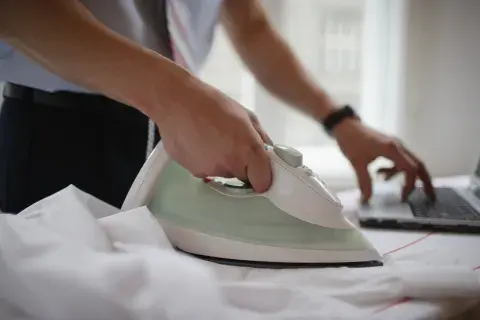 Una mujer planchando una camisa Una mujer planchando una camisa