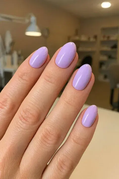 Una mujer con uñas en color lila Una mujer con uñas en color lila