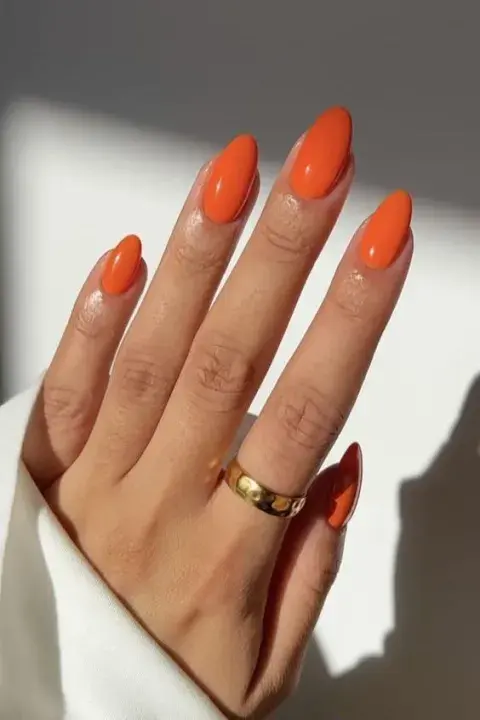 Una mujer con uñas en color naranja Una mujer con uñas en color naranja