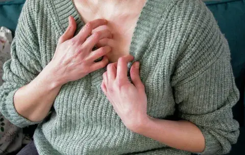 Una mujer rascándose el cuello por una alergia