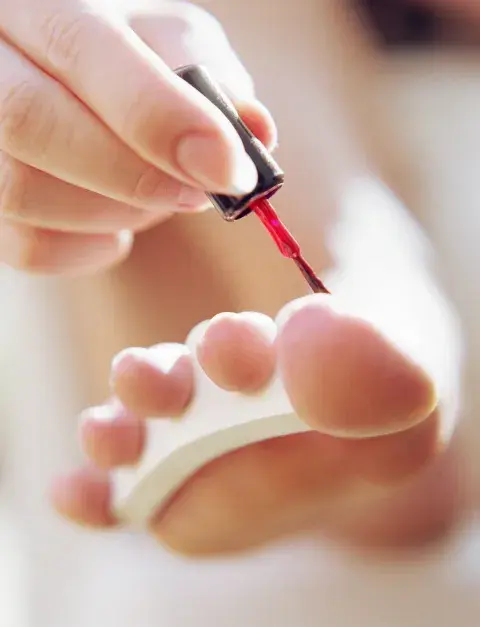 Una mujer pintándose las uñas Una mujer pintándose las uñas