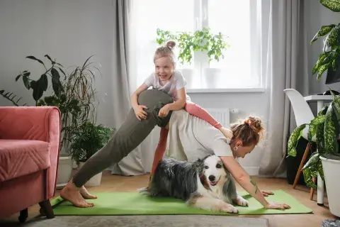 mujer haciendo postura de yoga con su hijo y un perro mujer haciendo postura de yoga con su hijo y un perro