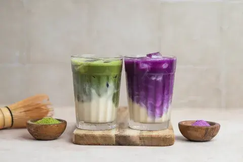 Vasos de ube y de matcha en una mesa. Vasos de ube y de matcha en una mesa.