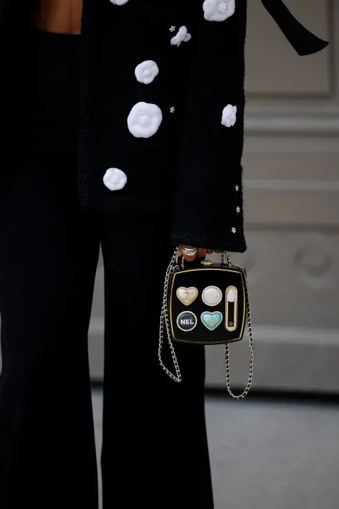 Una mujer con un look de Street style durante parís Fashion Week con bolso muy original Una mujer con un look de Street style durante parís Fashion Week con bolso muy original