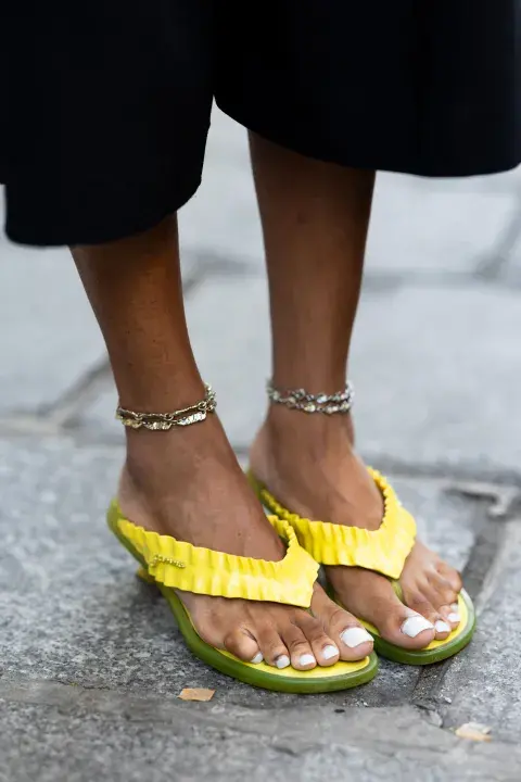 Una mujer por las calles de París con ojotas de color amarillo