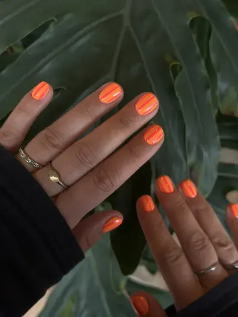 Uñas rayadas en color naranja