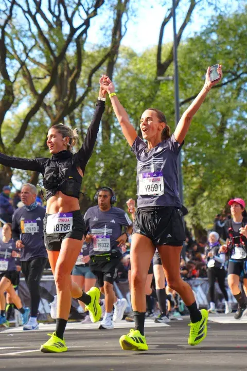 Mujer llegando a la meta de una maratón de running Mujer llegando a la meta de una maratón de running