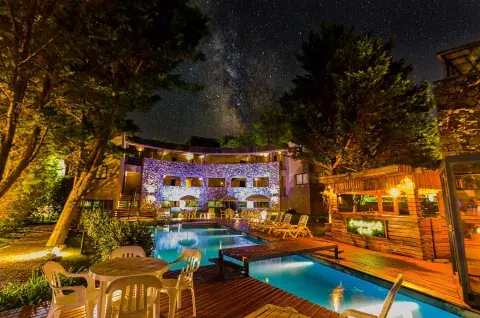 Un hotel iluminado con una pileta en el centro.