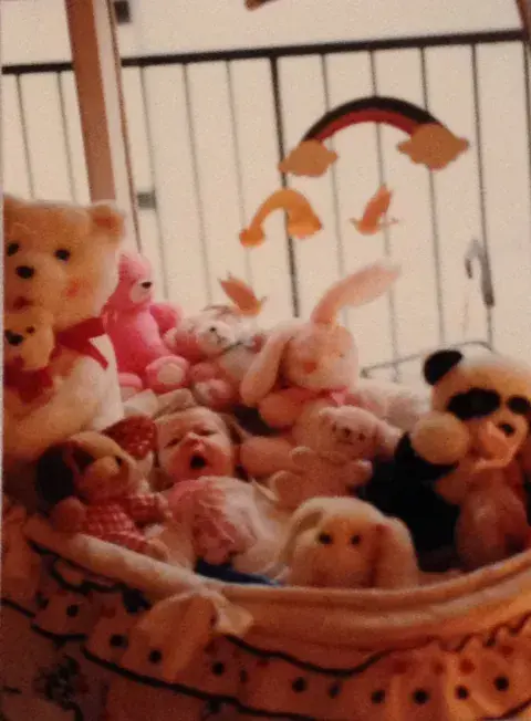 Entre tantos peluches estoy yo, súper chiquita, en el moisés