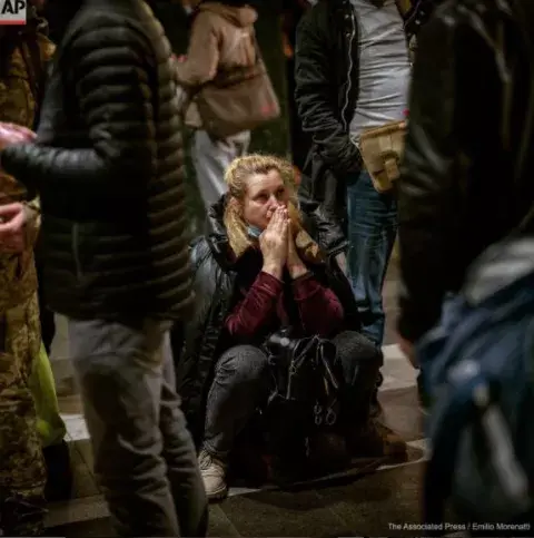 Una mujer espera un tren que intenta salir de Kiev, Ucrania. Una mujer espera un tren que intenta salir de Kiev, Ucrania.