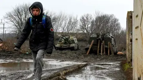 Ucrania: un niño camina con dos tanques a su espalda Ucrania: un niño camina con dos tanques a su espalda