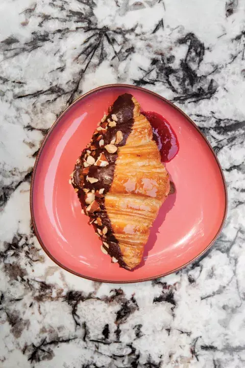 El favorito: el croissant bañado en chocolate y lleno de frambuesa