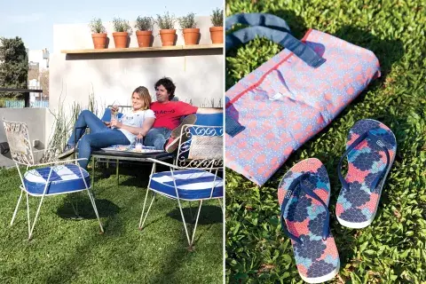 El jardín, con un césped que parece una alfombra, tiene un sillón de hierro negro con un almohadón de tela vinílica a rayas y un juego de silloncitos vintage comprados en el mercado de pulgas. Lona y ojotas (Seco, $490 y $270)