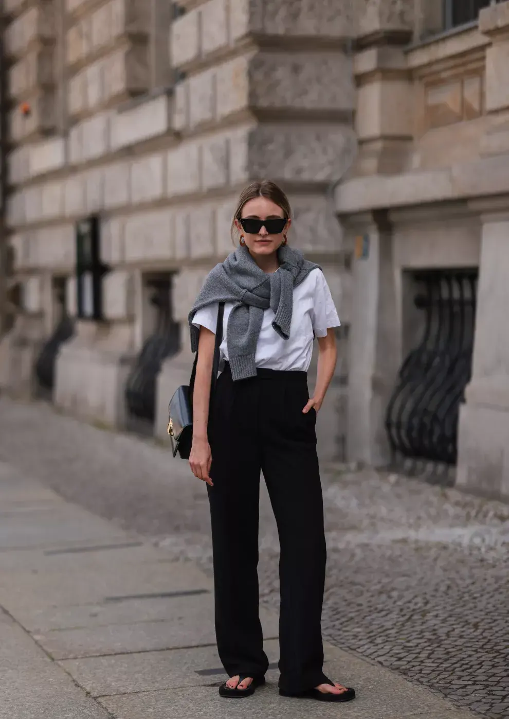 Remera blanca con pantalón negro y sandalias