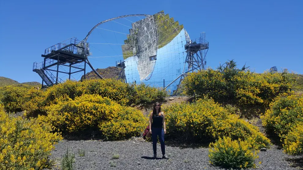 Carla feliz ante uno de sus elementos de trabajo, un telescopio profesional