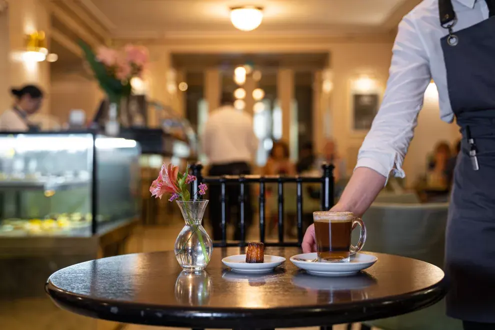 Una de las mozas sirve una mesa en la confitería Pasaje de los Carruajes en el Teatro Colón.