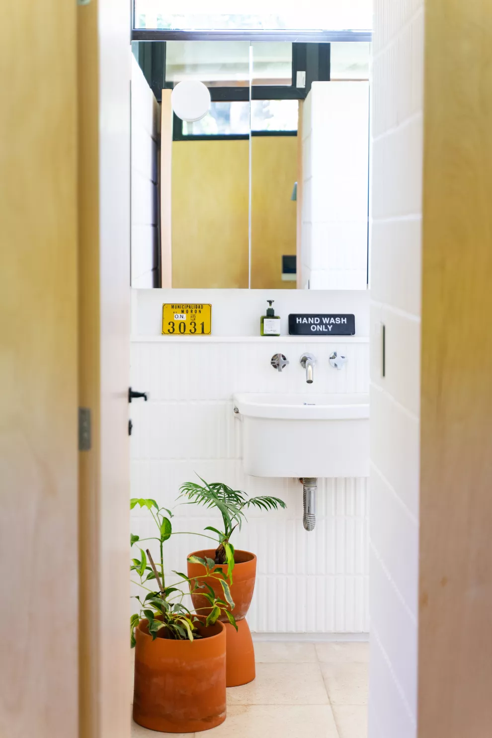 El baño, con el detalle verde de las plantas 