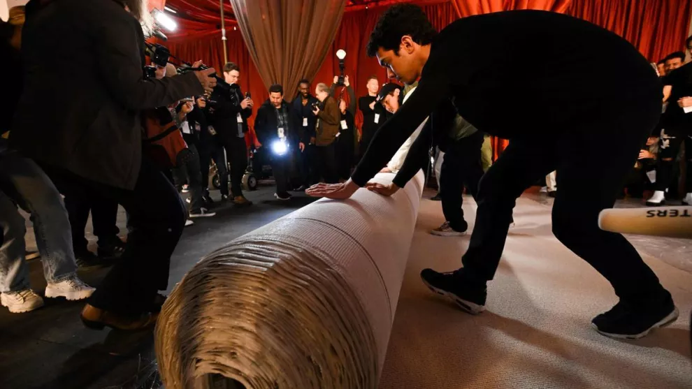 Los organizadores de los Oscar desplegando la nueva alfombra para la gala 2023.