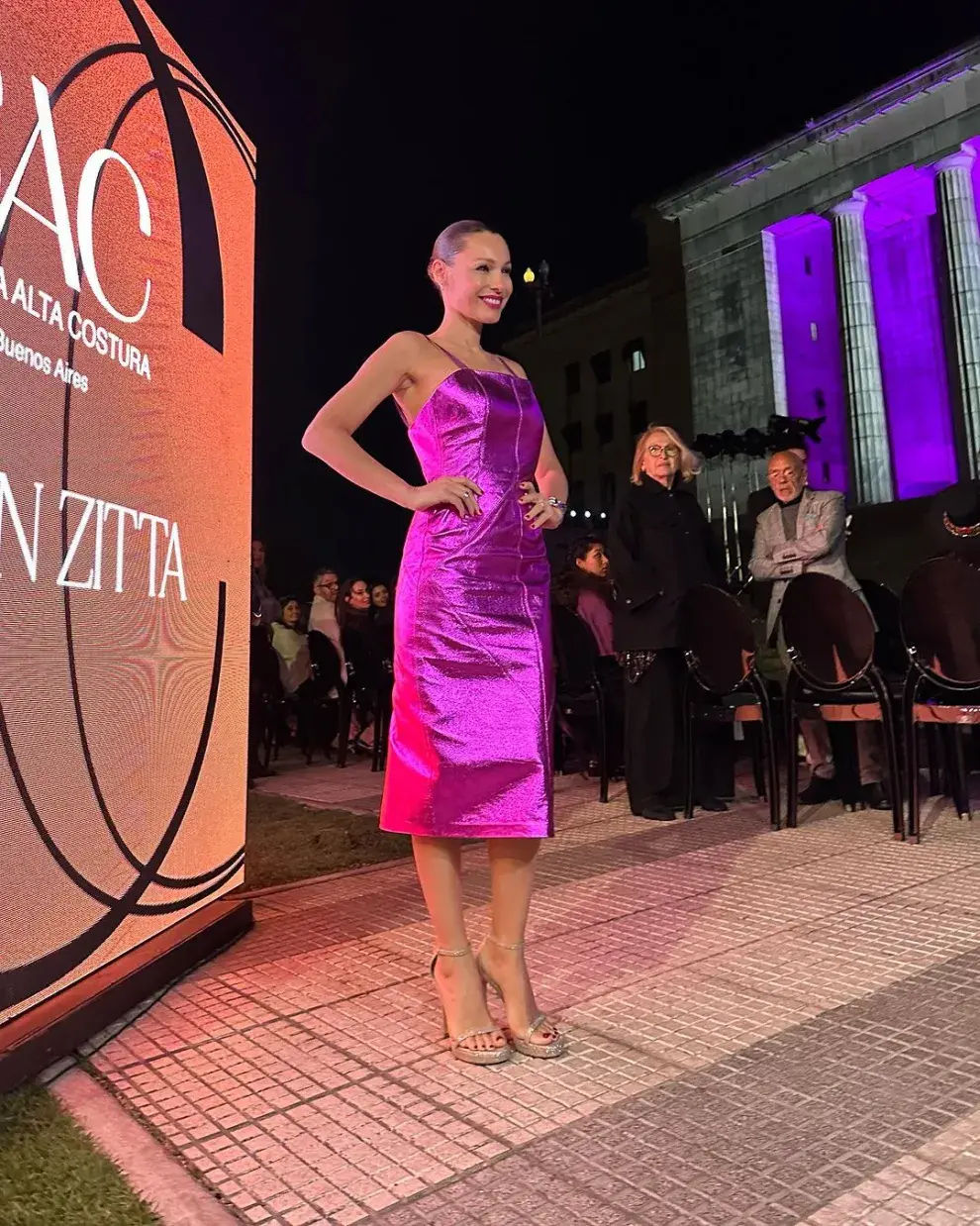 Un impactante diseño fucsia metalizado, al cuerpo y con falda por debajo de las rodillas.