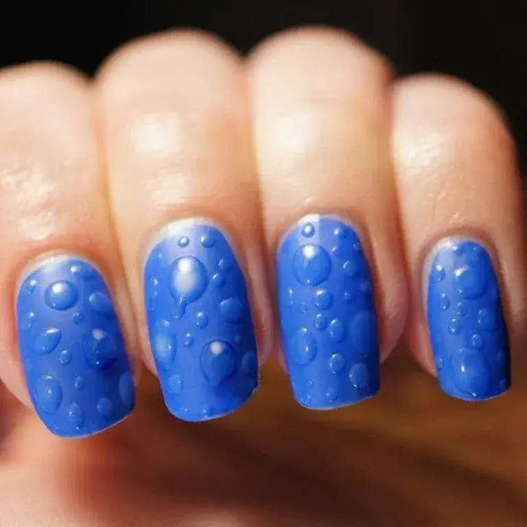 Uñas efecto wet o mojado en colores vibrantes, como este azul eléctrico.